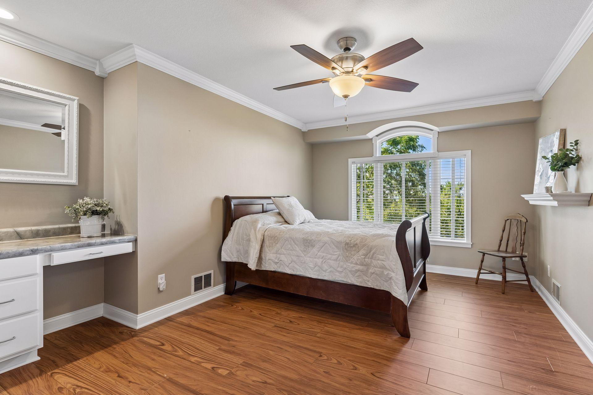 Large upper-level Bedroom featuring Crown Molding and a distinctive arched transom window that fills the room with natural light.