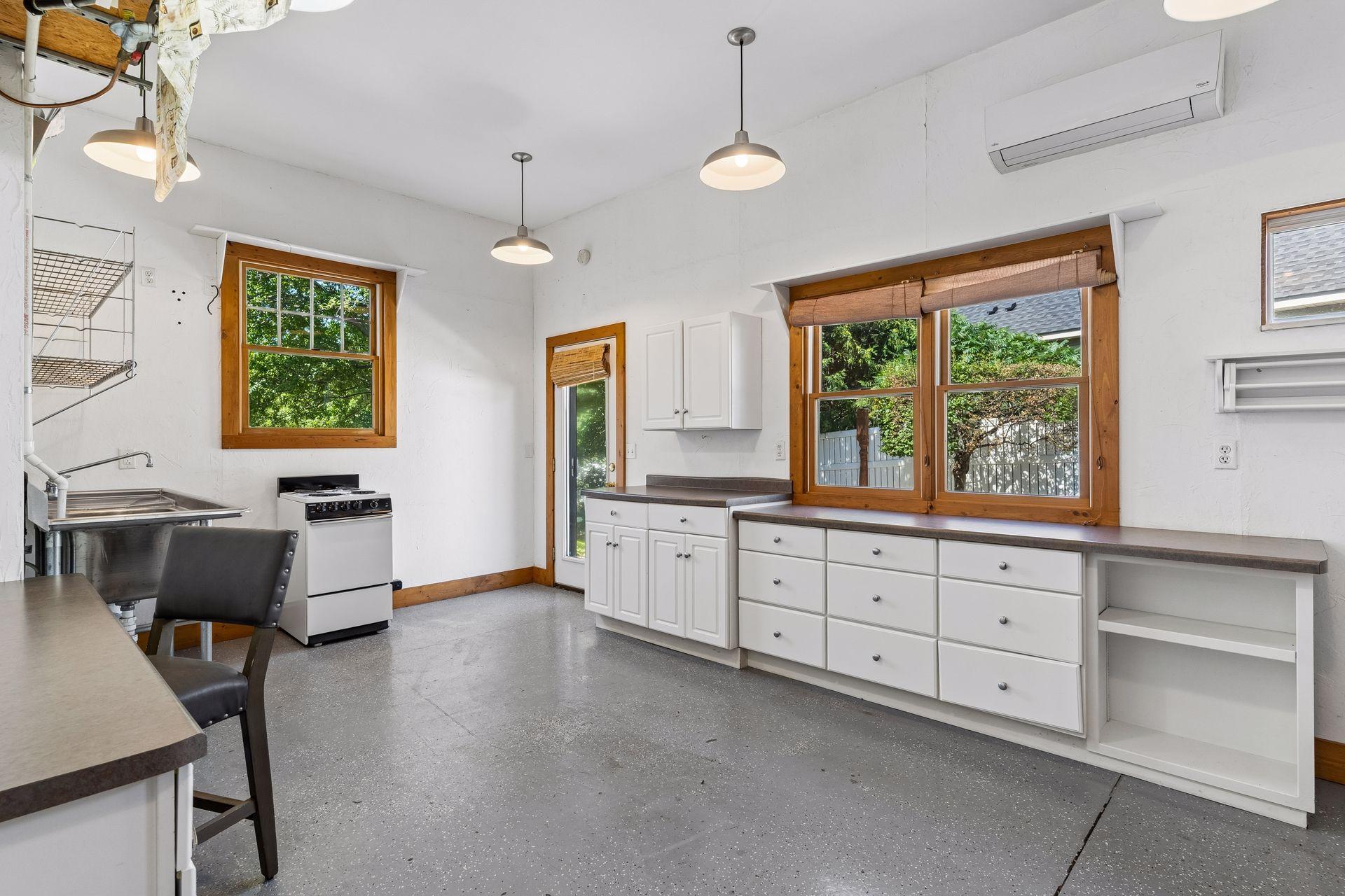 The 3rd Garage stall is a finished heated and air-conditioned flex room with cabinetry, work surfaces, utility sink, and exterior access. Great space for hobbies, gardening, a home business, or workshop. This can be converted back to simple be garage