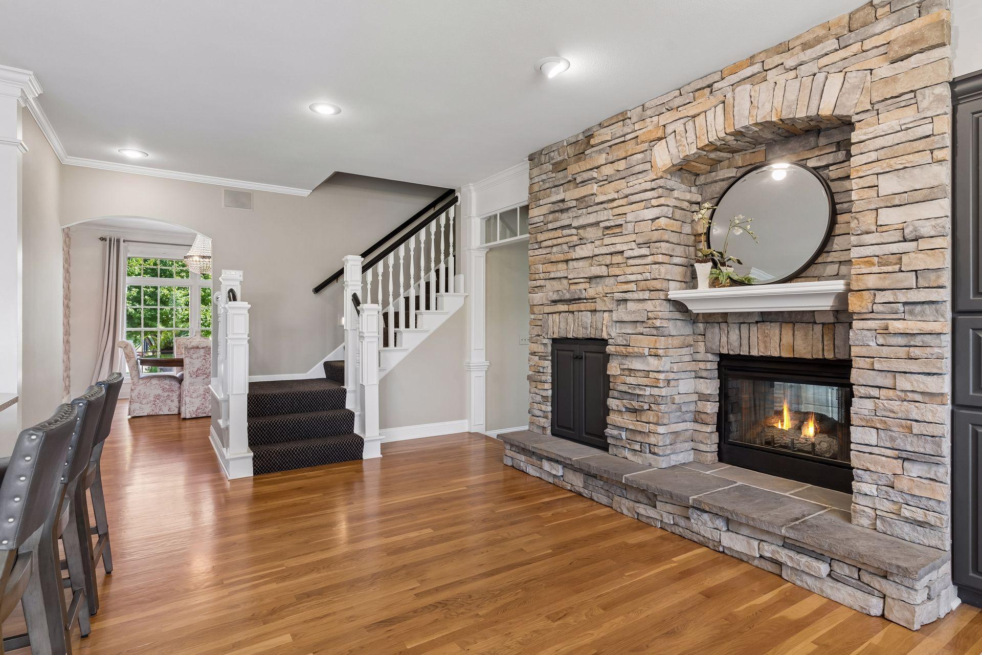 The Hearth Room offers a cozy place to gather, with a see-through Gas Fireplace, a view of the open staircase that leads to the upper level.