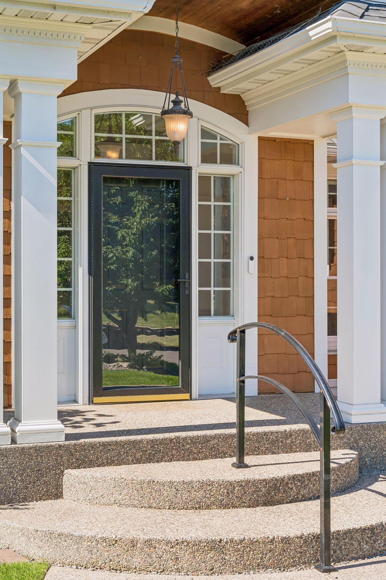The impressive curved wood front entrance creates a stunning first impression and showcases the exceptional craftsmanship found throughout the home.