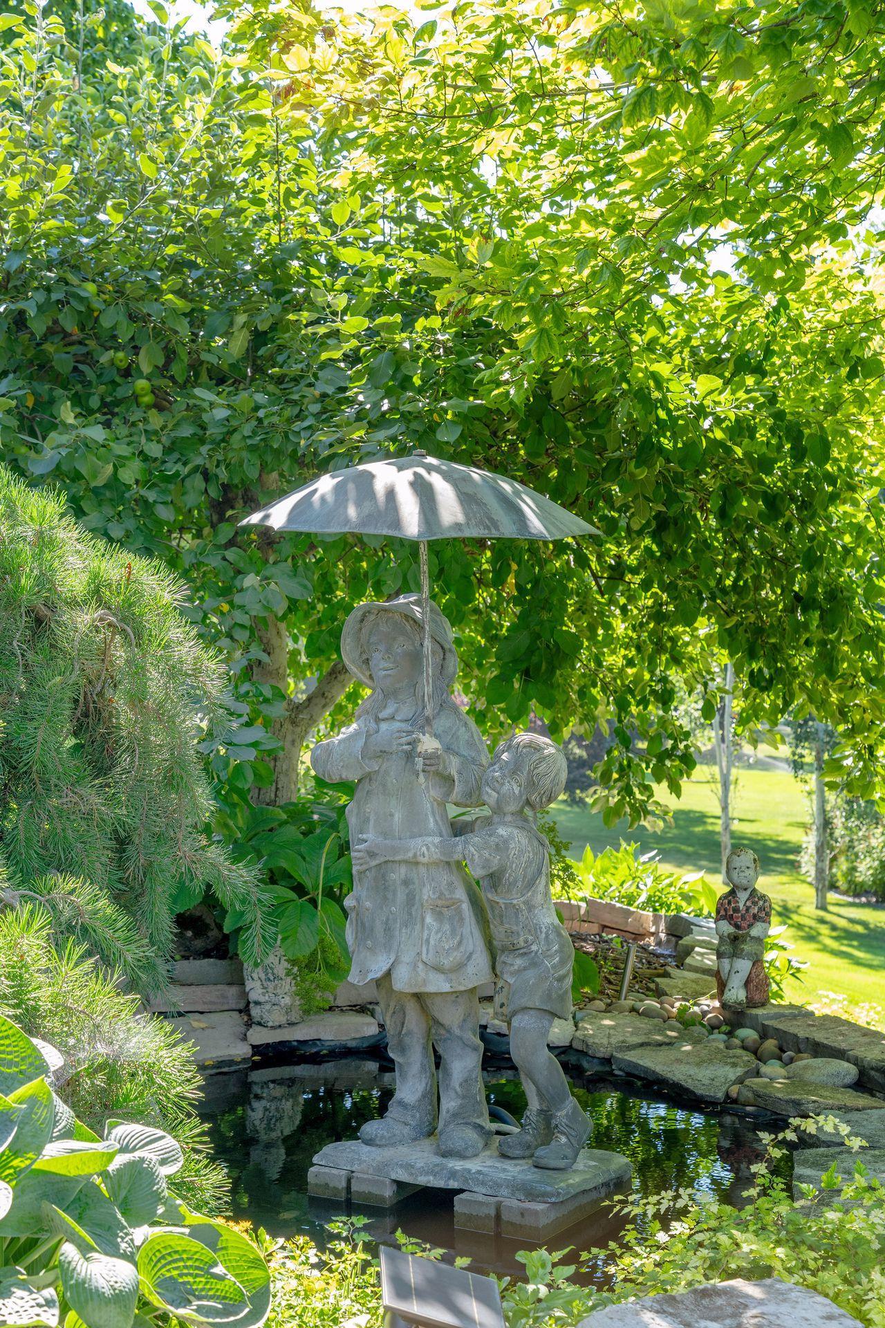Every corner of the gardens reveals another thoughtful detail, including a peaceful pond accented by a charming sculpture.