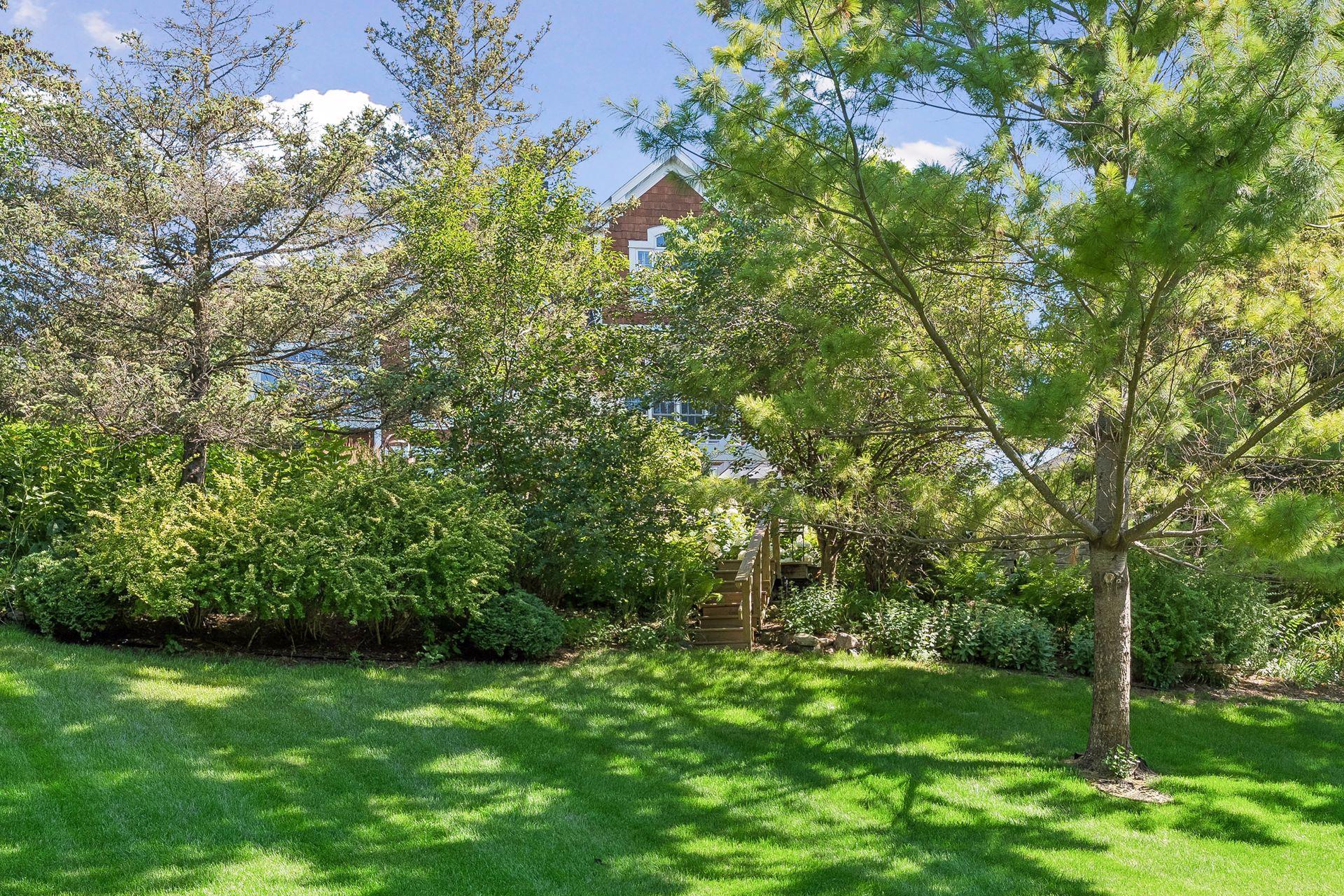 The upper gardens transition seamlessly to a spacious lower lawn, providing multiple outdoor living and recreation areas.