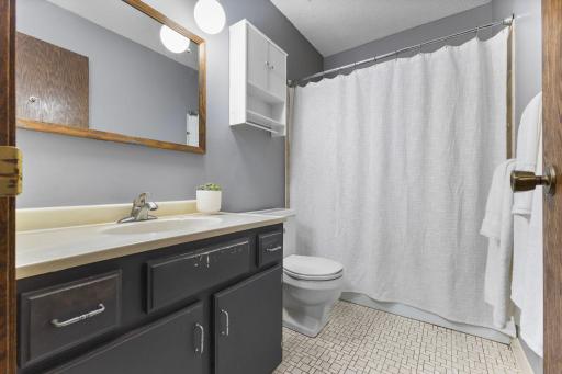 Main level full bathroom- tile floor and tile tub surround