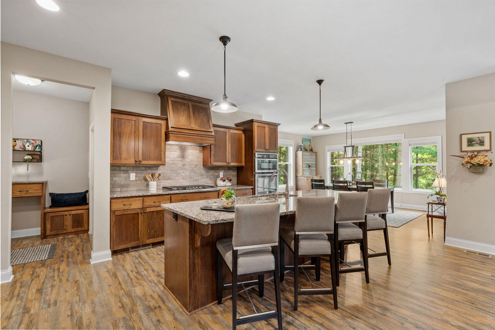 Gourmet Kitchen w/ granite counters, oversized island, SS apps, 5-burner gas cooktop, RO water system, cabinet pull-outs & walk-in pantry