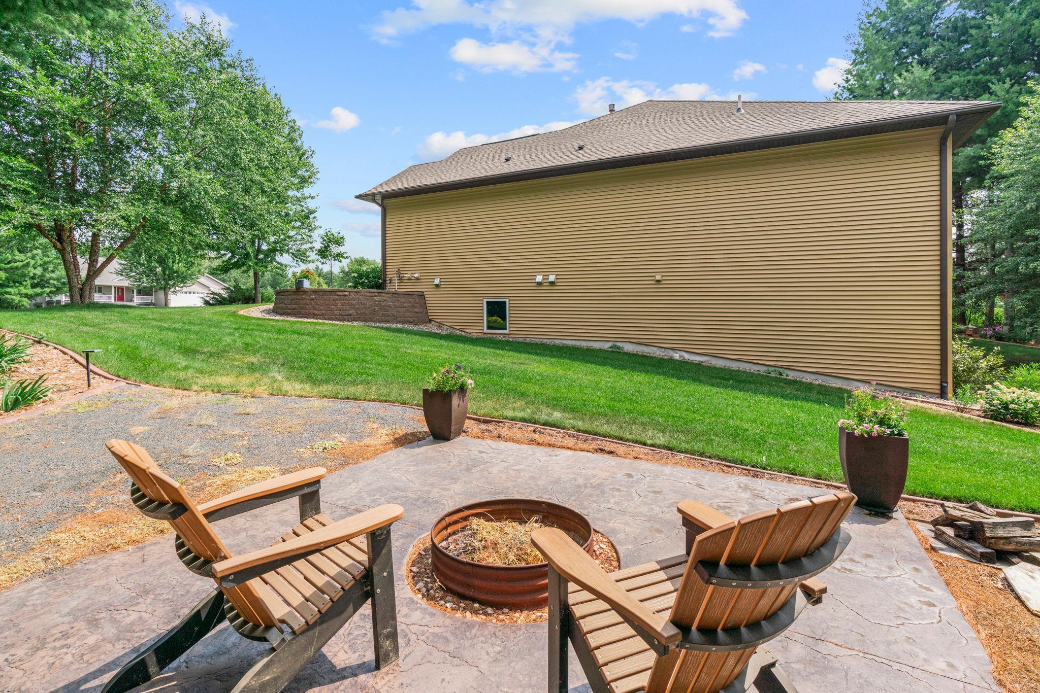 ncredible outdoor retreat w/ stamped concrete patio, built-in FP, expansive flat yard & peaceful wooded setting