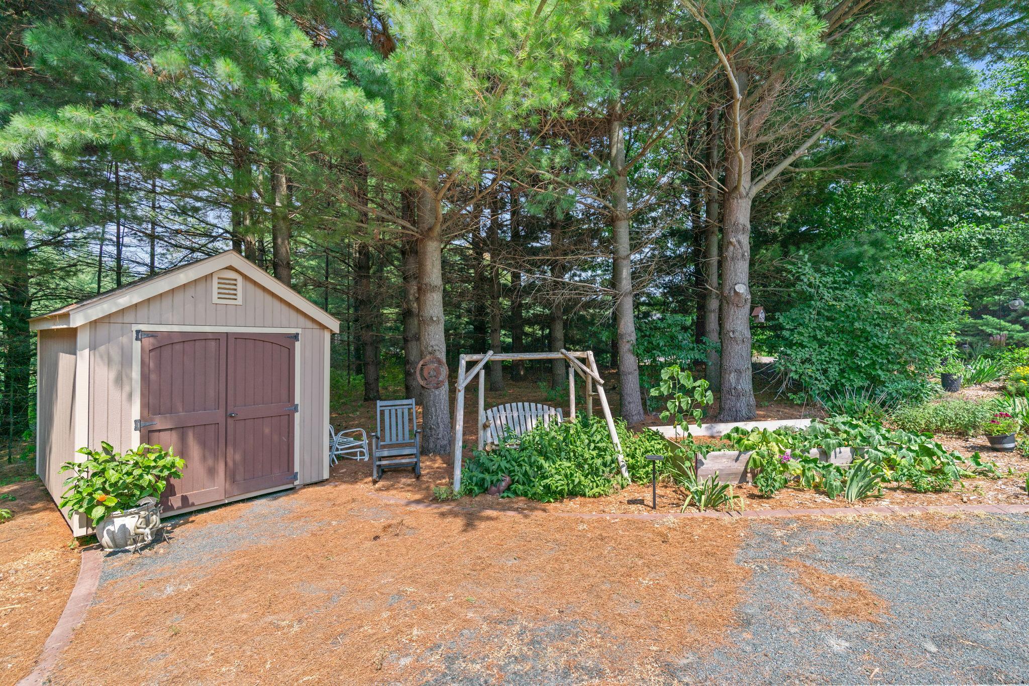 ncredible outdoor retreat w/ stamped concrete patio, built-in FP, expansive flat yard & peaceful wooded setting