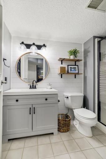 Lower level 3/4 bathroom with new vanity and refreshed shiplap accent wall