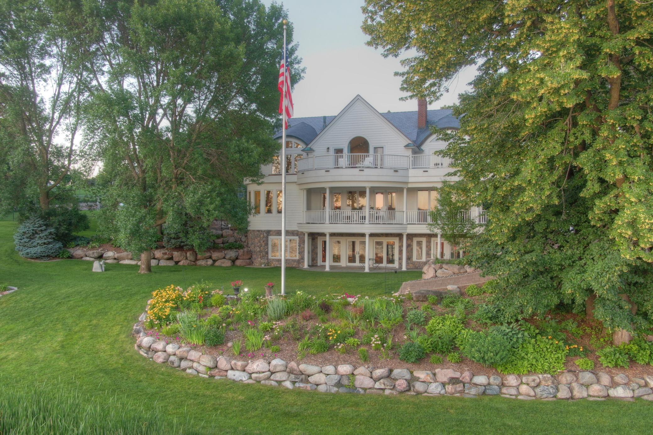 Surrounded by mature trees, lush perennial gardens, and boulder-lined landscaping, this beautifully maintained property feels like your own private lakeside park.