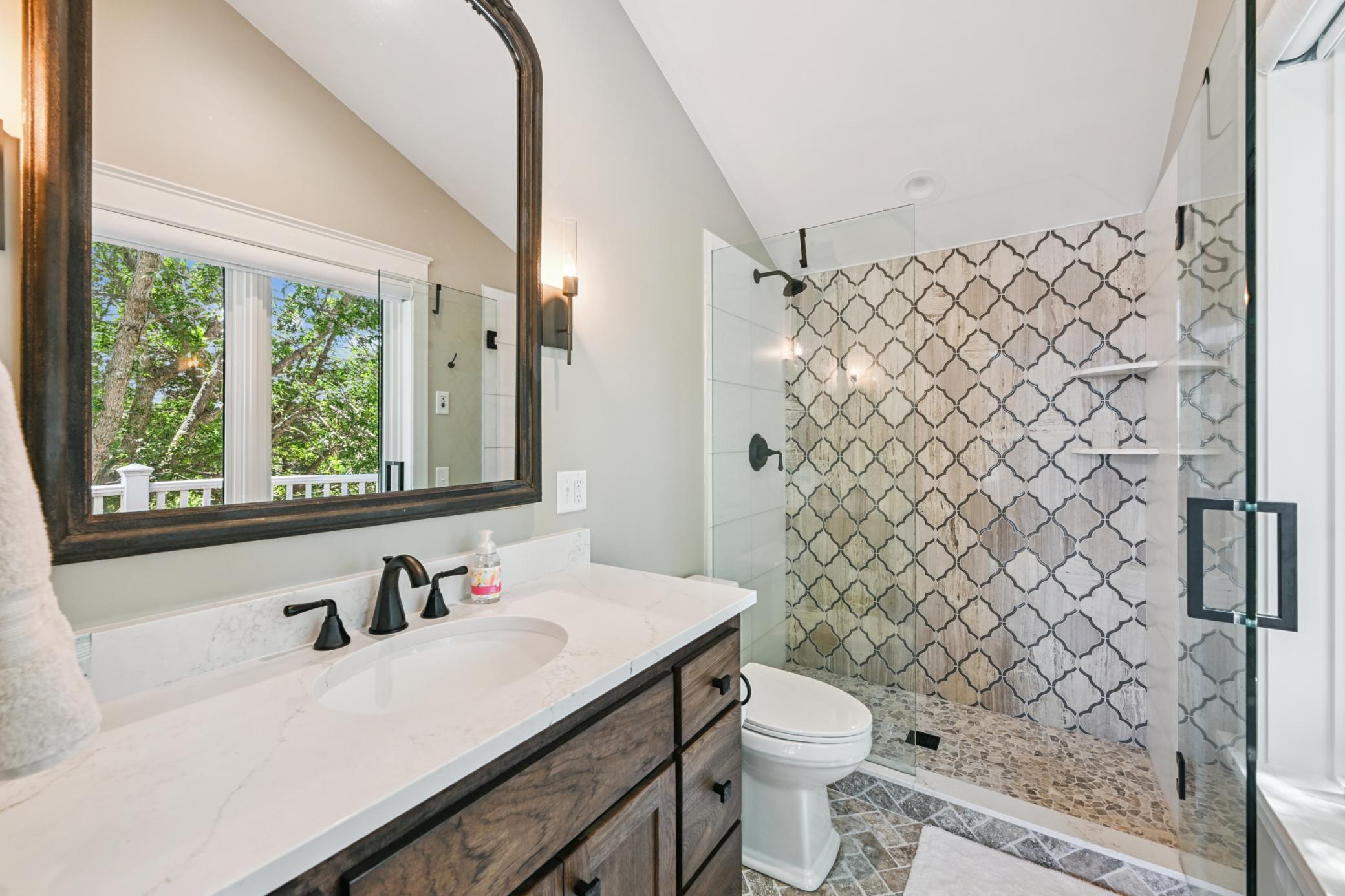 This private en-suite bath features a stylish tile walk-in shower and spacious vanity. The luxury touches that could easily make this bedroom feel like a primary suite in most homes.