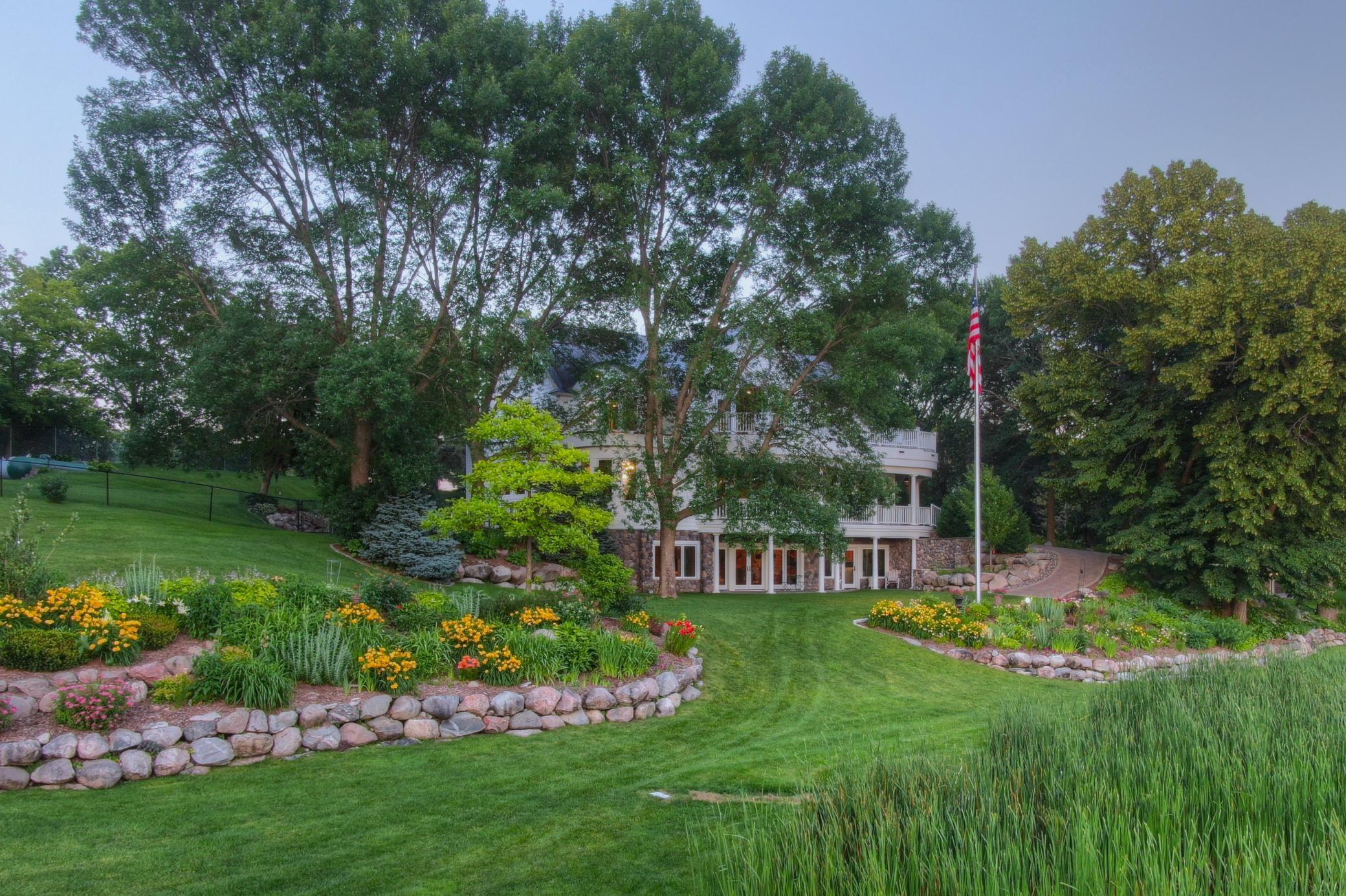 Expansive, gently sloping lawn provides a rare, step-free transition from the home to the lake ideal for easy mobility. Thoughtfully designed landscaping and paver pathways guide you past vibrant gardens and mature trees to the shoreline.