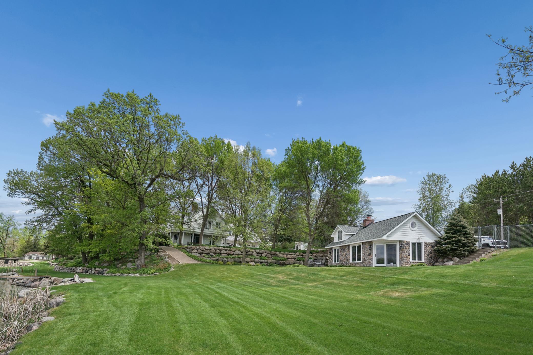 A traditional brick patio wraps around the guest cottage with panoramic views of Lake Sylvia. The perfect spot for outdoor dining, morning coffee, or sunset relaxation just steps from the shoreline in this exceptional lakeshore retreat.