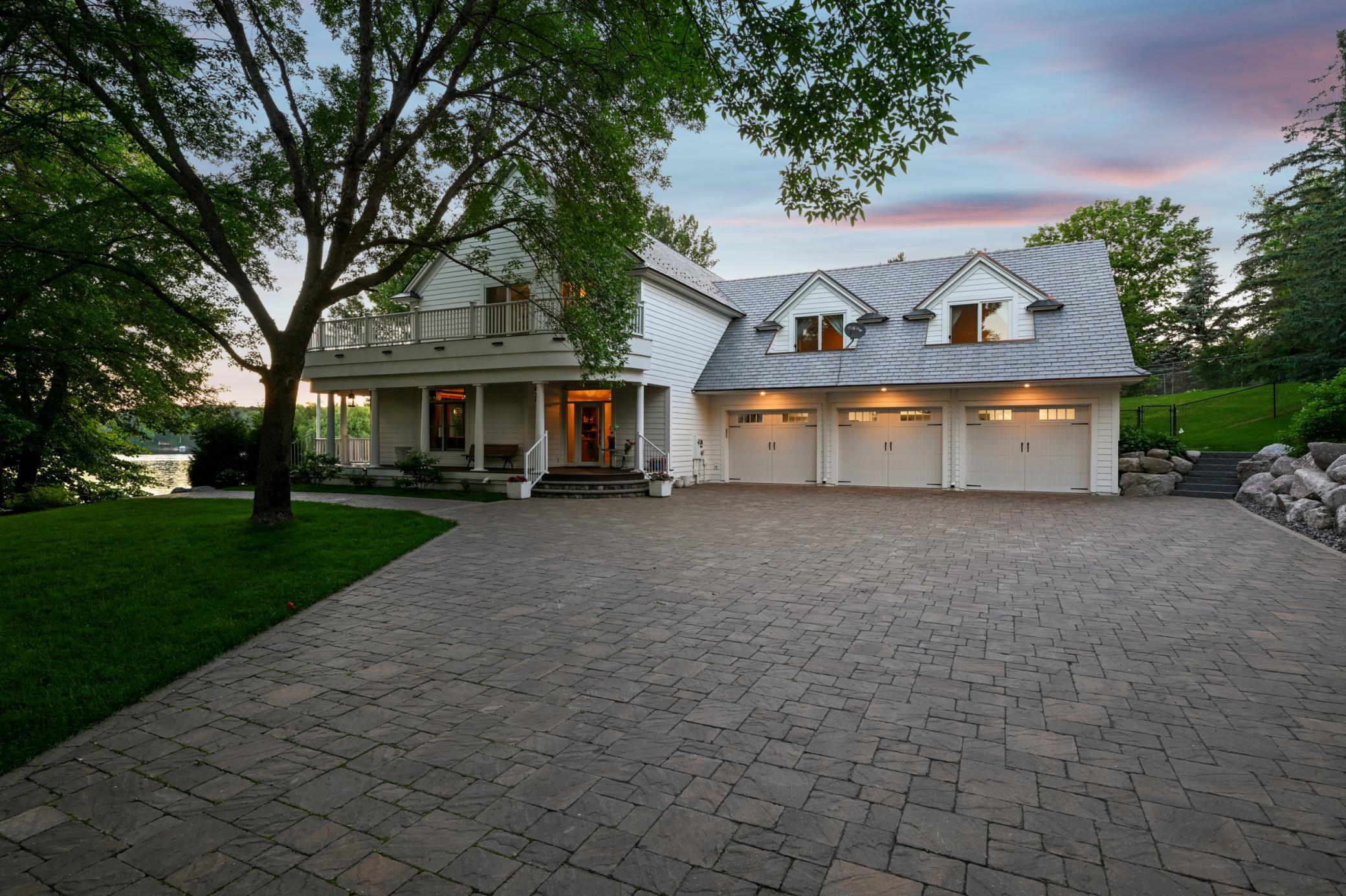 This impressive lake home showcases timeless architectural detail and thoughtful design. The expansive paver motor court leads to a 1,000+ sq ft heated garage with an epoxy floor offering, ample space for you and your guests to enjoy lakeside living.
