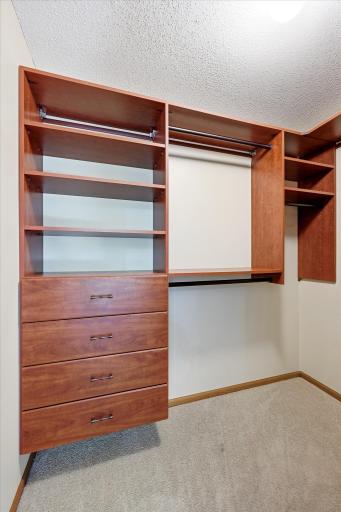 Primary walk in closet with built in storage space.