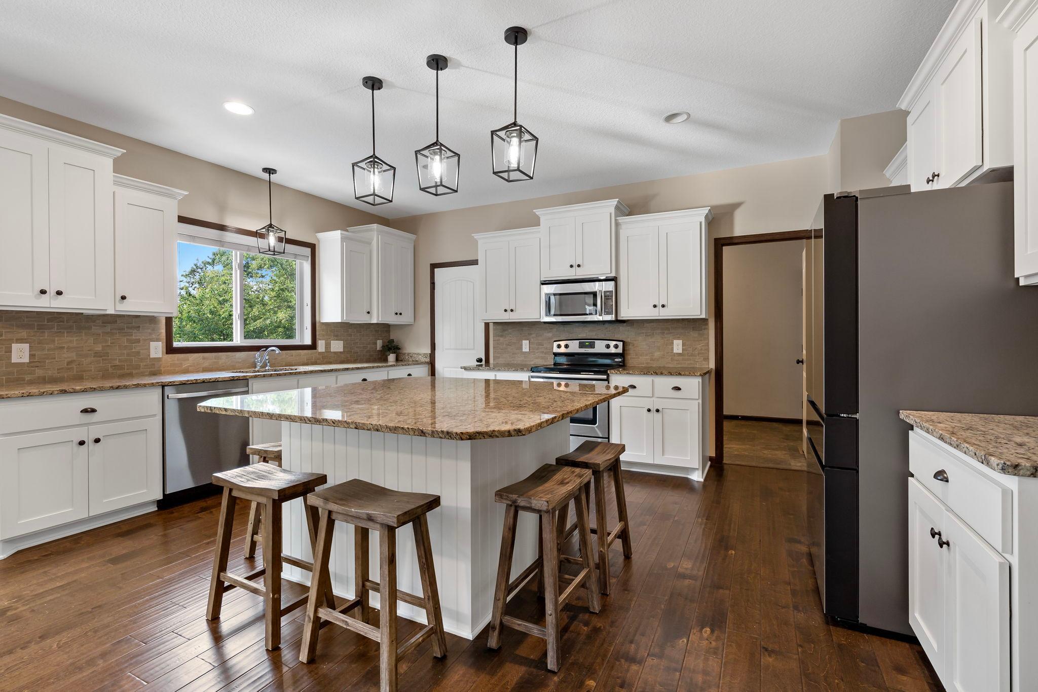 Bright and white kitchen with walk in pantry, newer fridge and dishwasher