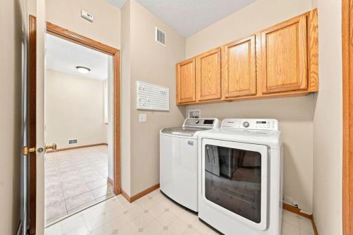 The laundry features convenient cabinetry and a utility tub in the mechanical area.