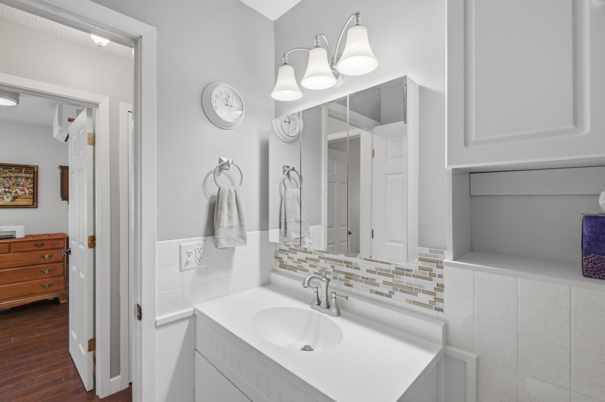 Enjoy extra counter space and lots of storage in the updated bathroom. The backsplash and lighting gives an elevated feeling.