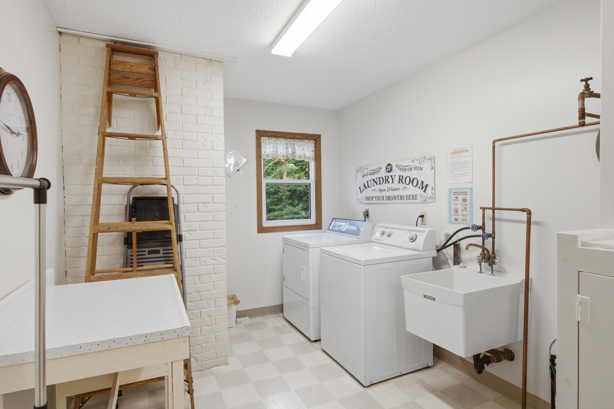 The spacious community laundry area offers folding space, a sink, and a rolling rack for hanging clothing. Laundry is located just out the unit door, to the right, across the 3rd floor landing,