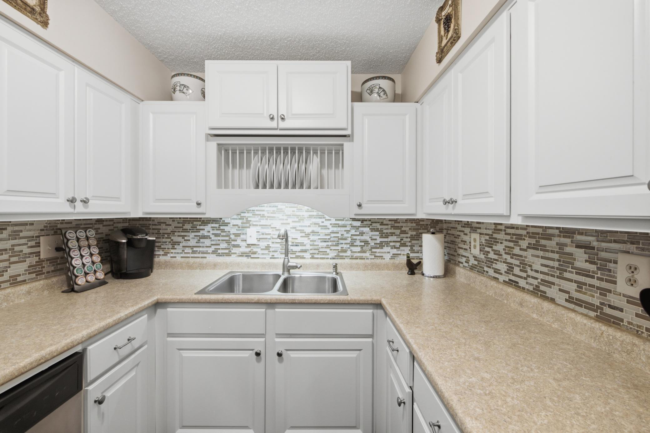 This kitchen has been updated and features a classic backsplash which elevates this space. Ample counter area for your use, and easy storage access for your seasonal items.