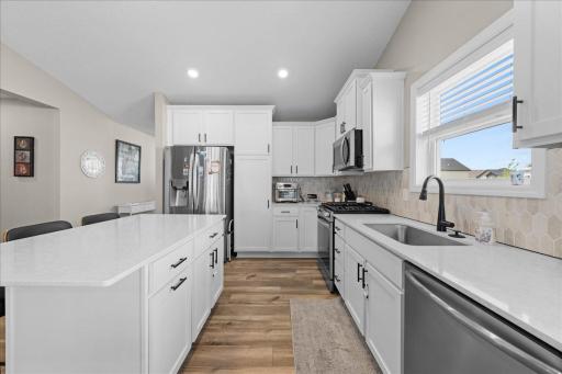 Stainless steel appliances and white cabinetry add to the shine of the kitchen.