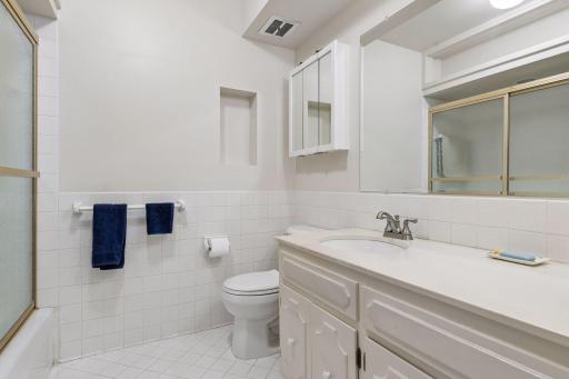 Main floor full-bath with glass door enclosure.