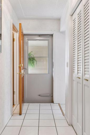 Attractive foyer with white ceramic tile flooring and a large coat closet.