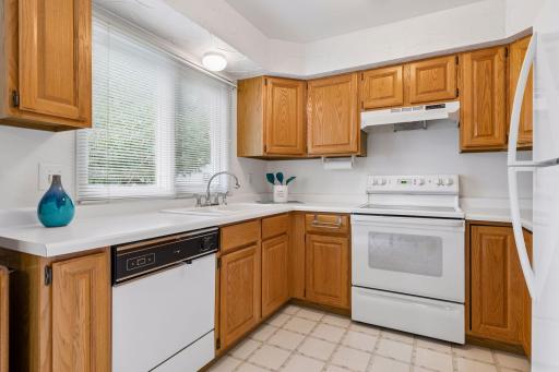 The spacious kitchen is well-appointed with a full appliance package. Large kitchen window overlooks backyard.