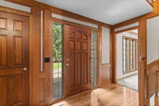 Greeted with wood floors and stately solid wood paneled wainscot
