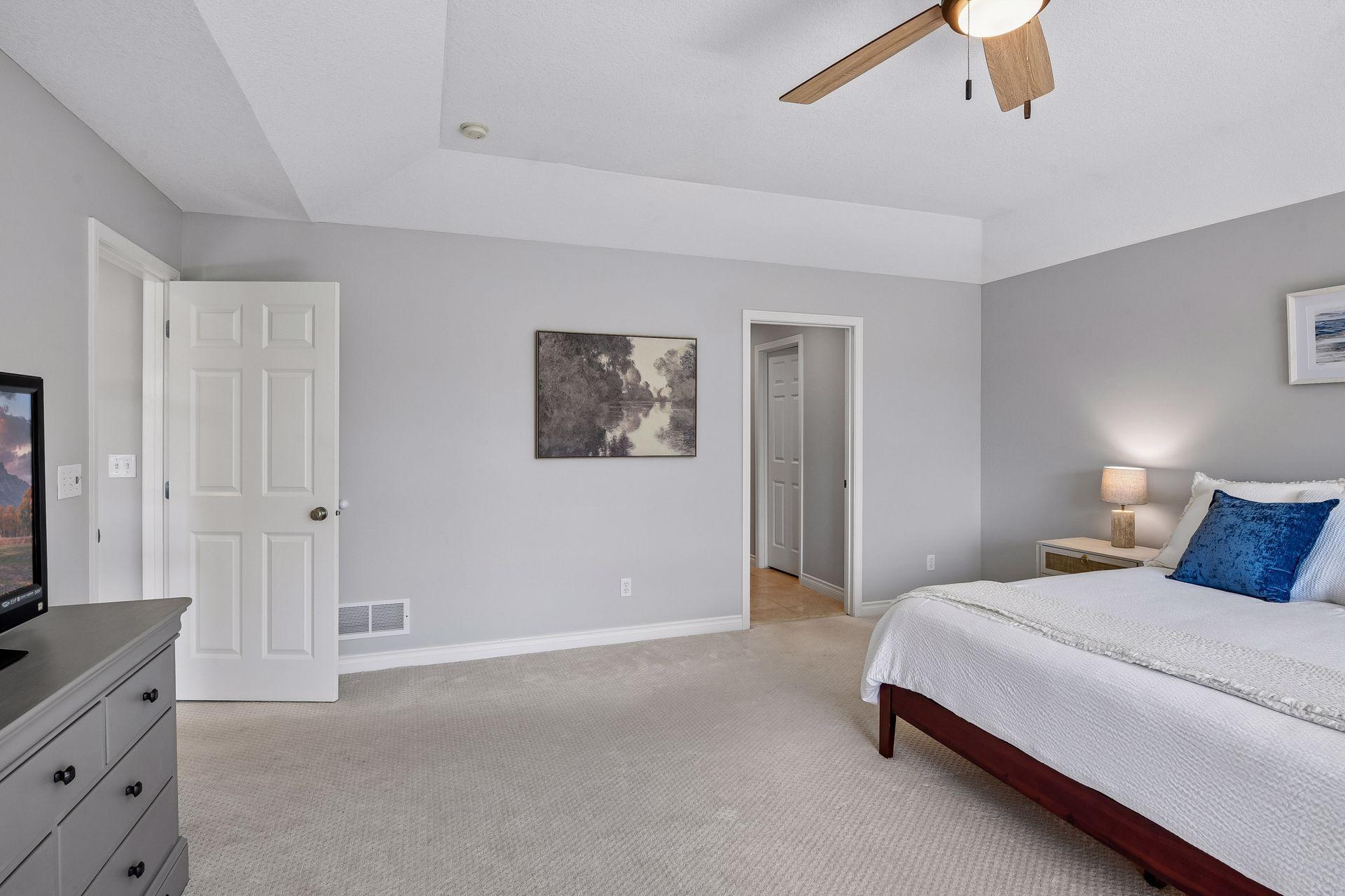Primary bedroom showcases a tray ceiling and ceiling fan for comfort1879 Sandbar Circle - Spacecrafting - 0029.jpg