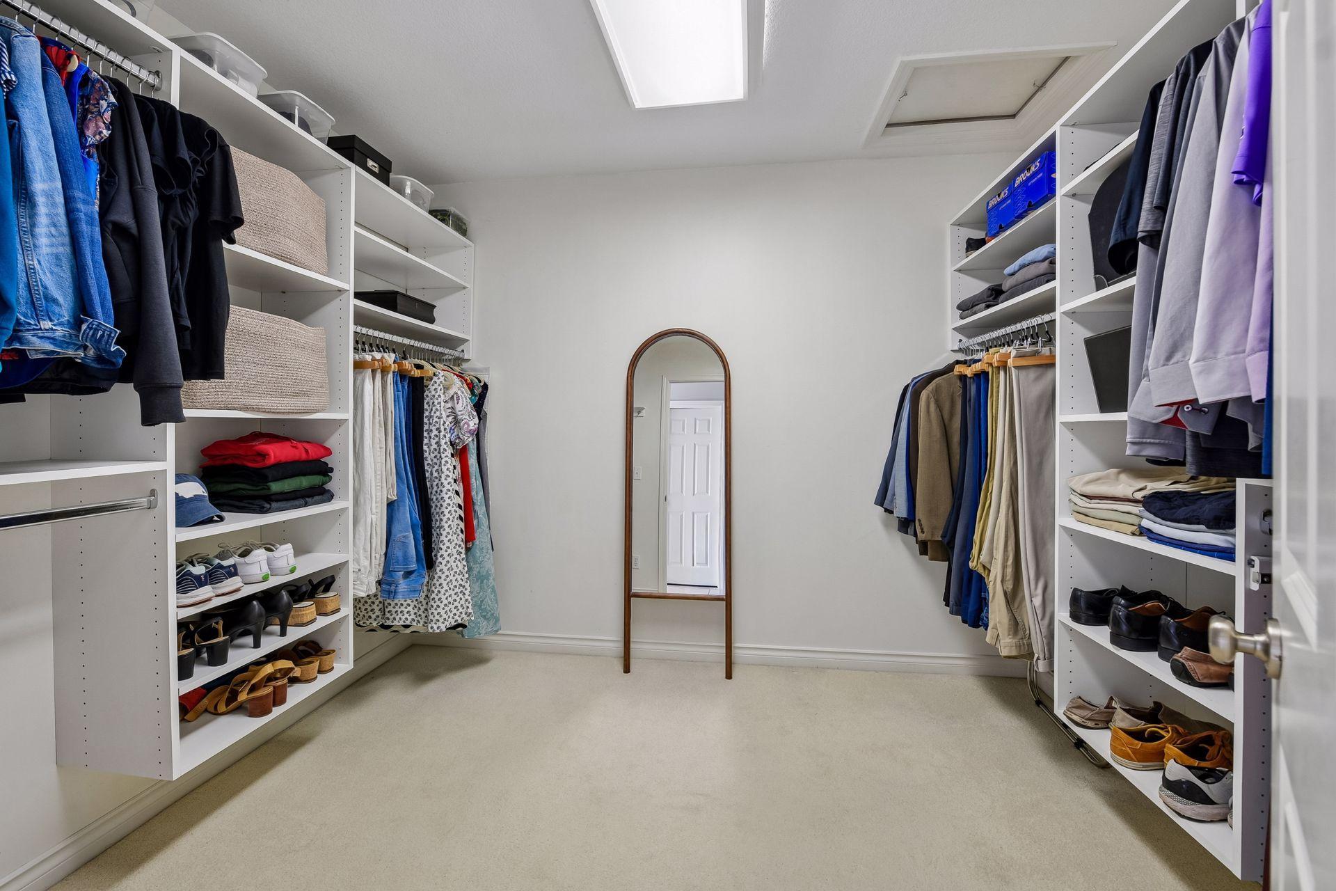 Primary walk-in closet complete with closet organizers