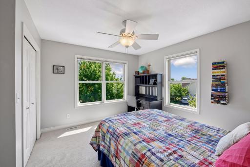 Bedroom #4 on the upper level complete with corner windows and ceiling fan