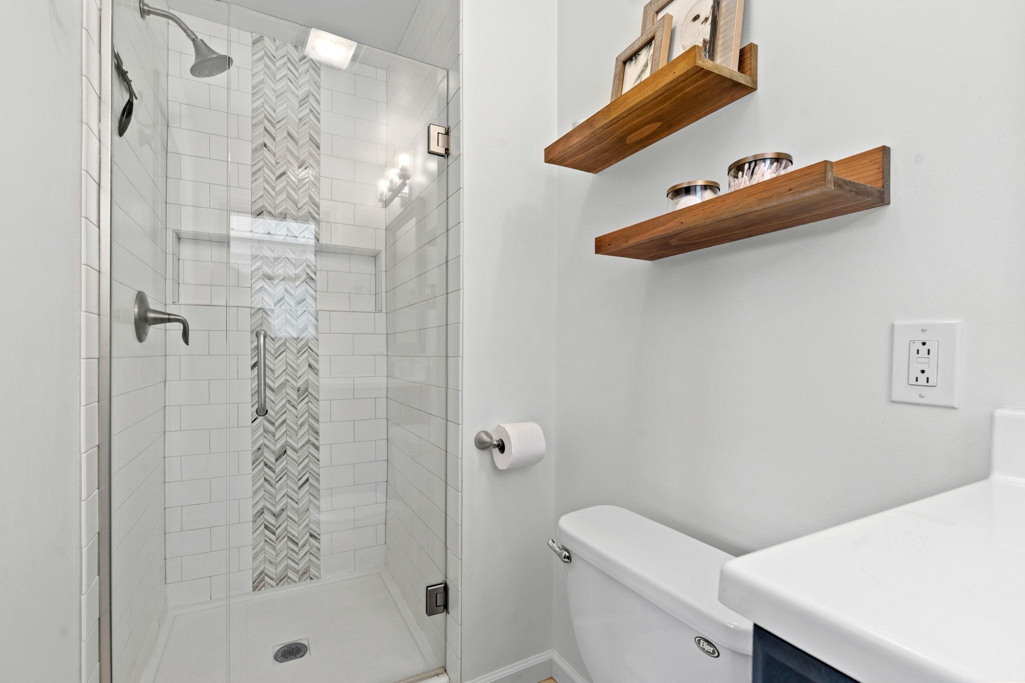 Updated bathroom features new tile shower