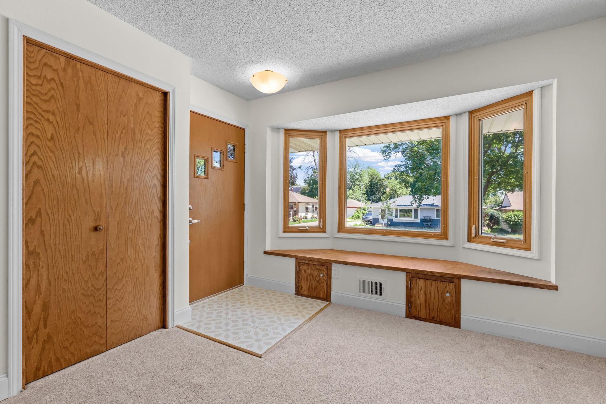 Spacious entryway with bench seating and coat closet