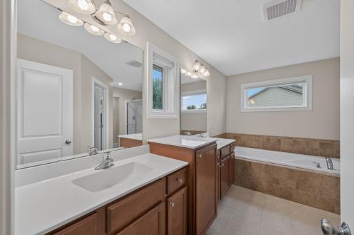 Designed with relaxation in mind, this spacious primary en-suite bathroom offers dual vanities, a luxurious soaking tub, and a separate shower, creating the perfect place to refresh, recharge, and unwind.