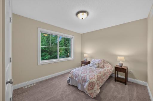 Overlooking lush scenery, the 4th bedroom on the upper level offers a comfortable layout and abundant natural sunlight.