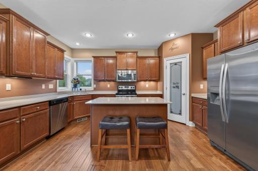 Rich cherry-stained cabinetry, warm engineered hardwood flooring, and clean, timeless finishes create a kitchen that's both elegant and practical for everyday living.