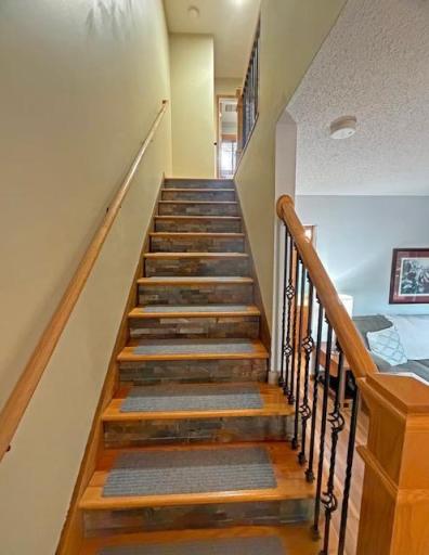 Solid hardwood stairs with tile accents and safety treads are practical. Wood balusters, newel, posts and rails were installed to enhance the look.