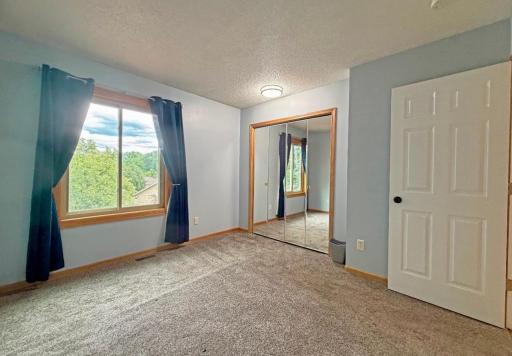 The second bedroom is large and features a mirrored closet.
