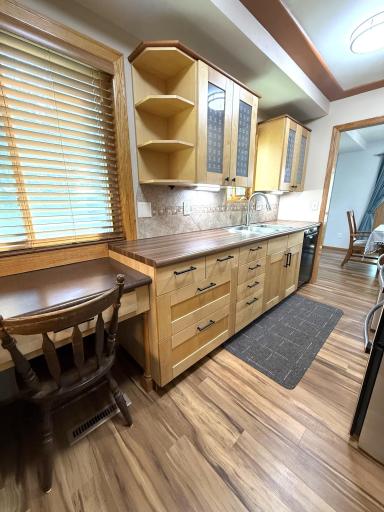 Kitchen is enhanced with under cabinet lighting and a lovely tile backsplash.