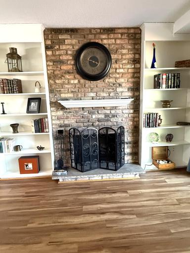 The brick fireplace is wood burning. The white book shelves are built in.