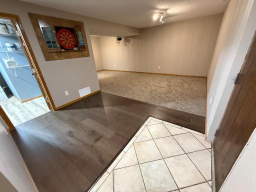 White tiled foyer contrasts well with the newer flooring and carpeting.