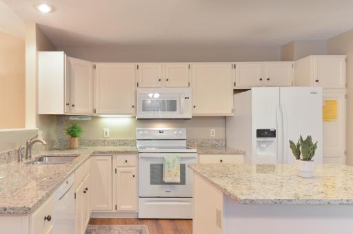 Bright, spacious kitchen featuring abundant cabinetry, generous counter space, and a large center island.