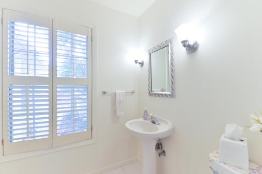 Spacious main-level owner's bath featuring a large vanity, separate shower, soaking tub, and convenient walk-through design.