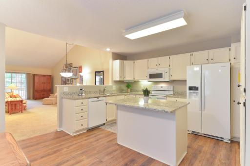 Bright, spacious kitchen featuring hard surface countertops, abundant cabinetry, and a large center island.