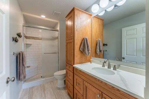 Primary bath has updated tiled shower, flooring and lighting.