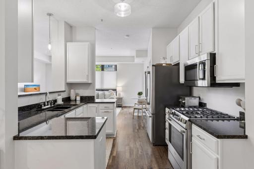 The granite and white cabinets in this kitchen give a sleek look. The gas range is rare. If gas wasn't plumbed when new, you can't add it later.