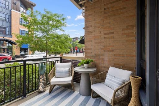 A concrete patio is raised slightly and has brick corner niches and shrubs which provide privacy.