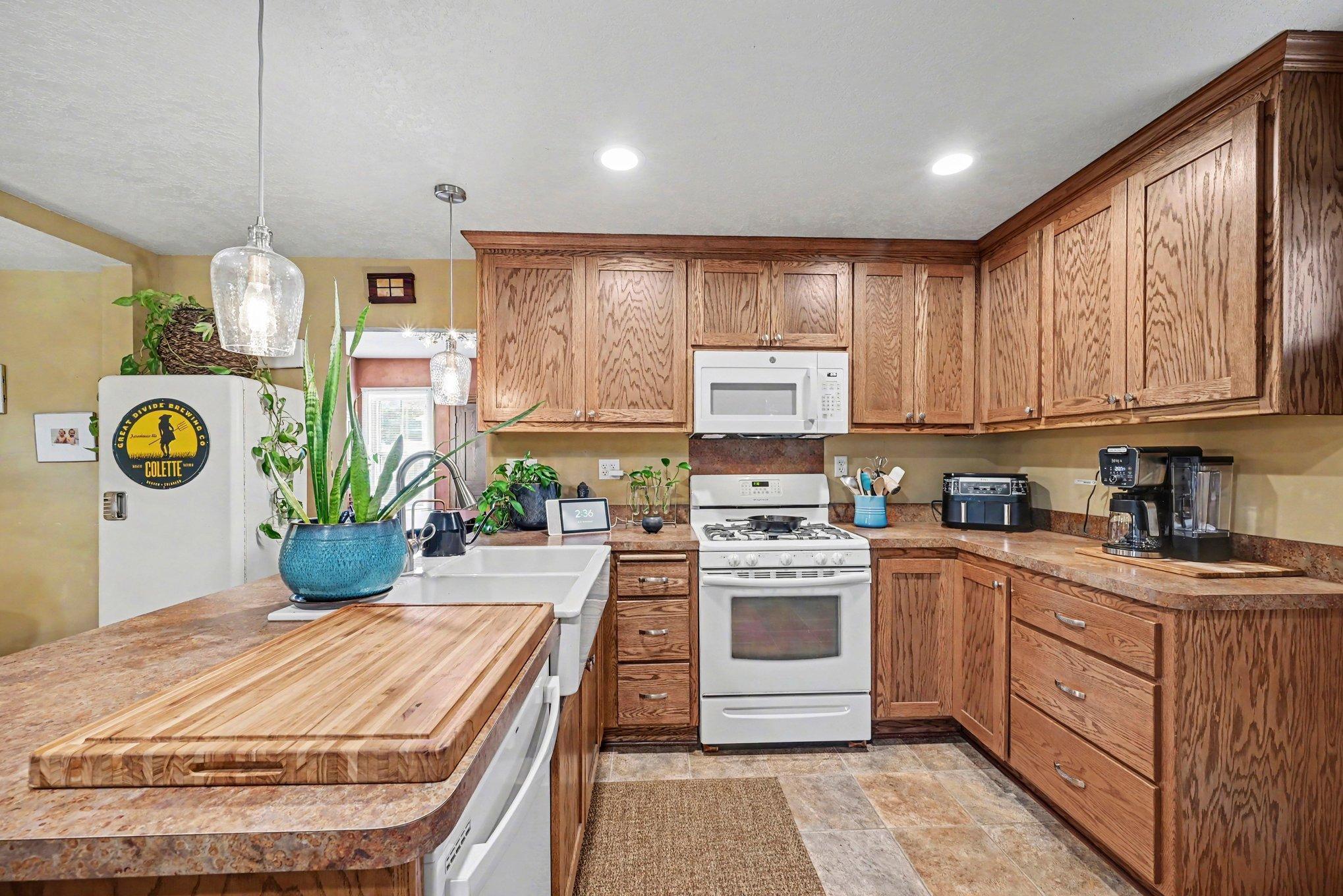 As you enter the home from the back door, you're met with a completely remodeled kitchen featuring shaker style oak cabinets, rich woodwork, and gorgeous farmhouse sink!