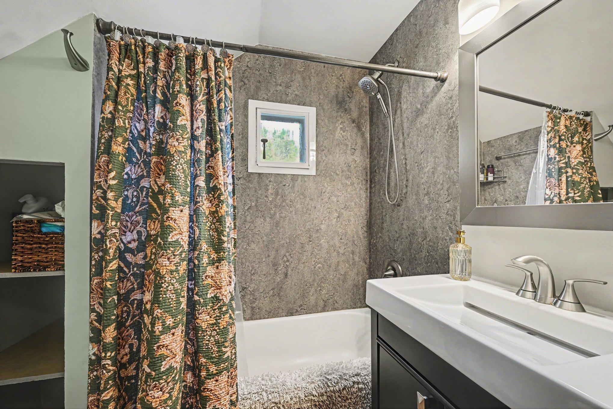Updated full bath with eco-friendly Marmoleum on floor and surround and in hallway. Storage for towels and more.