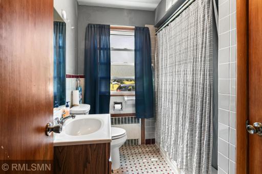 Main level full bath with original ceramic floor and wall tile.