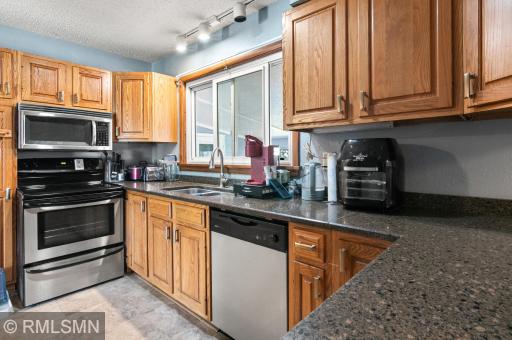 Oak cabinets, granite counters, window overlooking the enclosed porch and back yard.